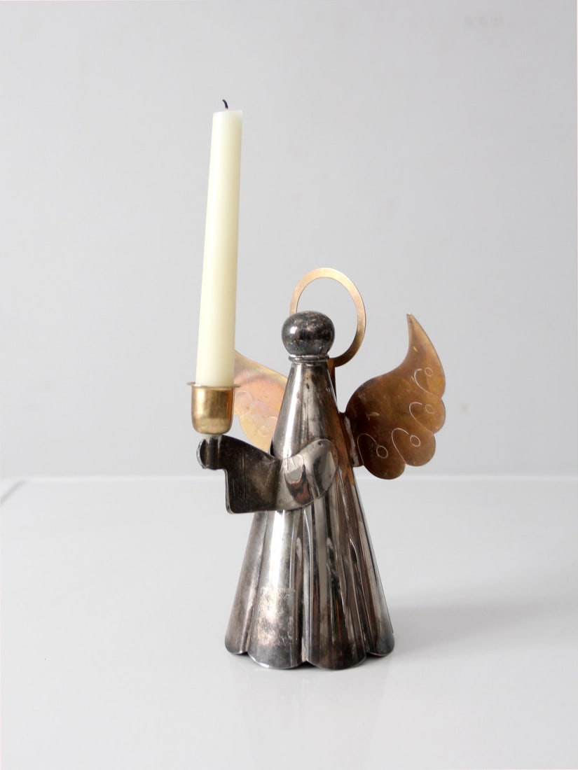 Vintage Angel Candleholder in Silver and Brass Tones: Vintage Angel Candleholder in Silver and Brass Tones Enhance your home decor with this Vintage Angel Candlestick Holder, a captivating blend of silver and brass tones. The softly flared base and polis