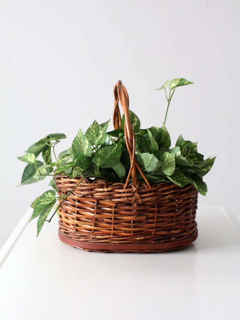 Charming Vintage Wicker Basket with Wood Base and Handle: Charming Vintage Wicker Basket with Wood Base and Handle This vintage wicker basket is a charming and functional piece for any home. It features a sturdy woven design with a top handle and a wooden ba