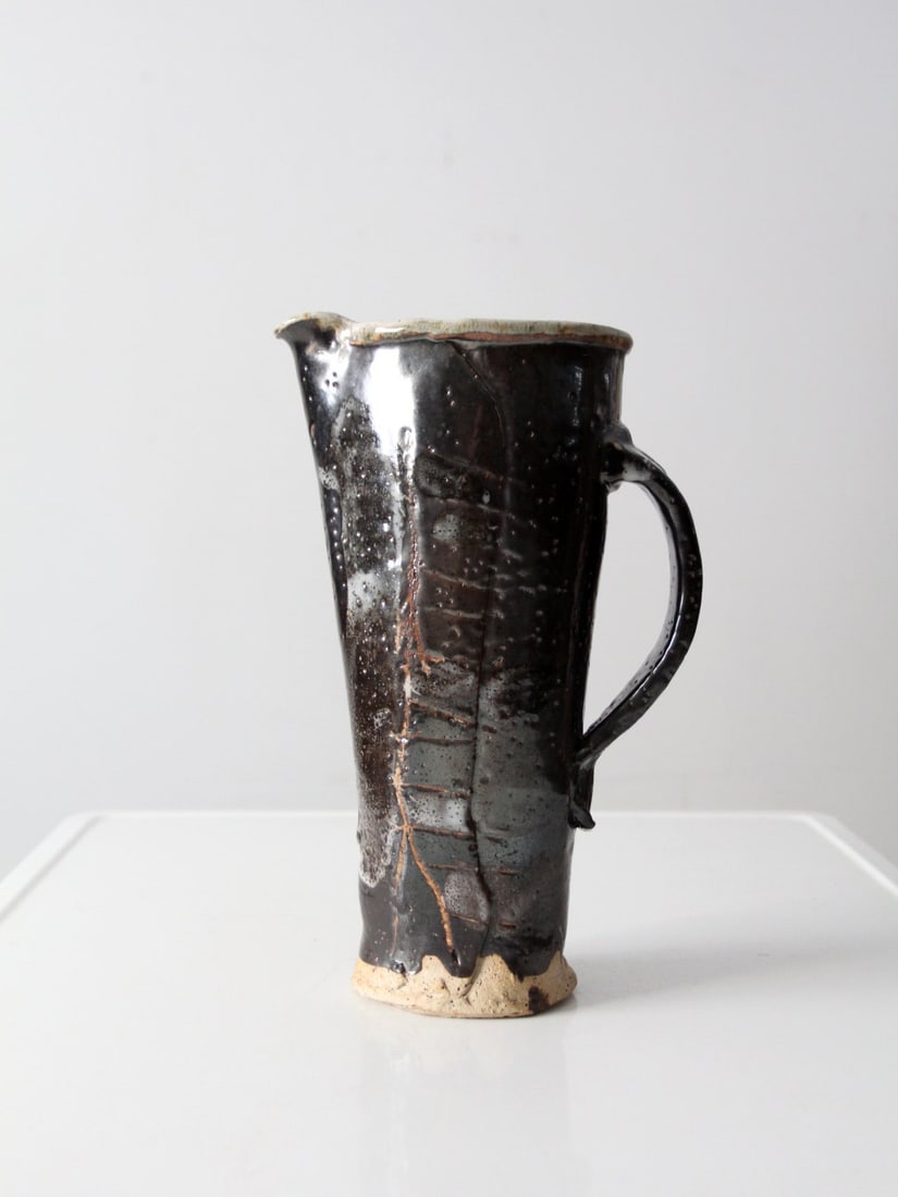 Rustic Vintage Studio Pottery Pitcher Vase with Brown Glaze: Rustic Vintage Studio Pottery Pitcher Vase with Brown Glaze This vintage studio pottery pitcher is a stunning hand-crafted piece that showcases a large rustic design. It features a rich deep brown gla