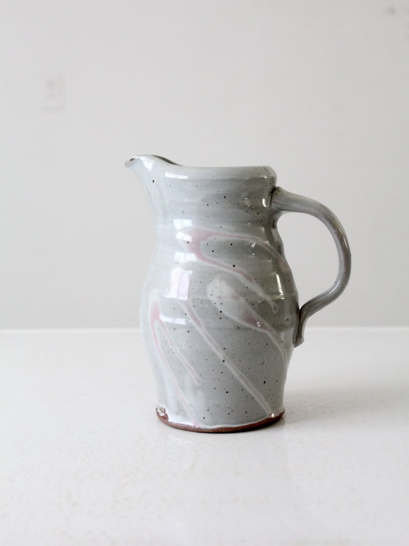 Handmade Vintage Dove Gray Studio Pottery Pitcher: Handmade Vintage Dove Gray Studio Pottery Pitcher Discover the charm of this vintage studio pottery pitcher, a unique handmade ewer in a soft dove gray color adorned with beautiful splashes of pink an