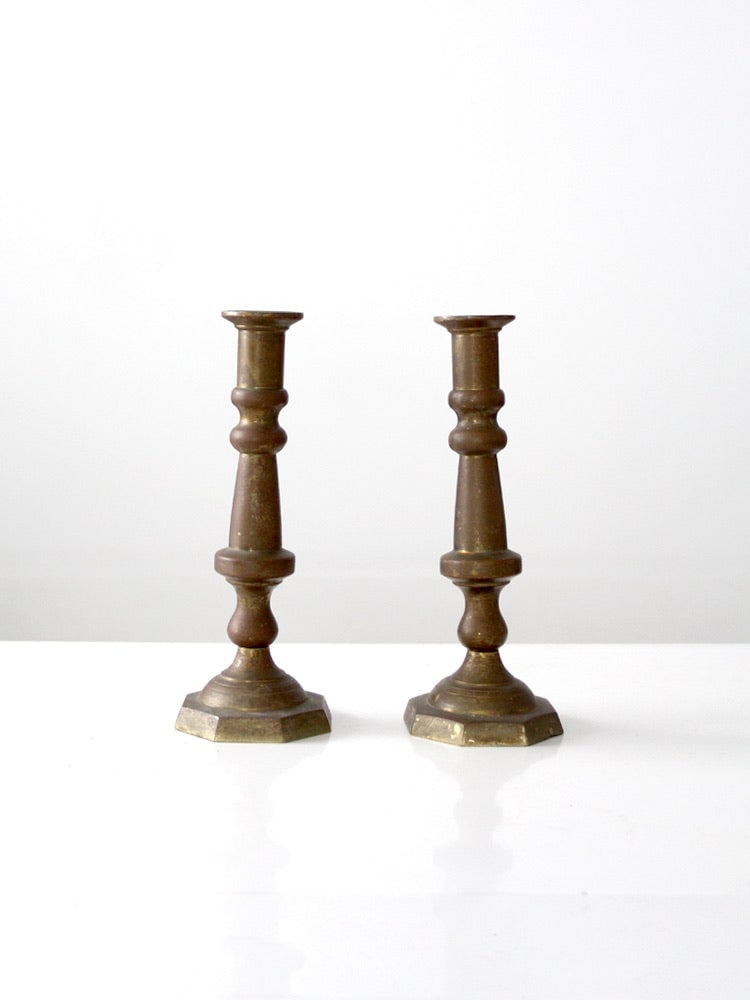 Pair of Hecho en Mexico Brass Candle Holders with Turned Stems: Pair of Hecho en Mexico Brass Candle Holders with Turned Stems This pair of vintage brass candlestick holders features turned stems and octagonal bases with a softly aged brass surface. Marked 'Hecho