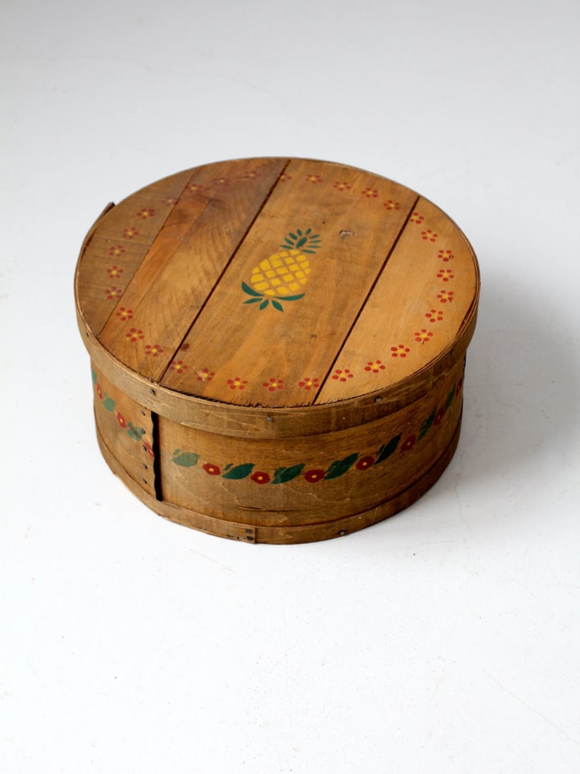 Rustic Vintage Stenciled Wooden Cheese Box with Pineapple Decor: Rustic Vintage Stenciled Wooden Cheese Box with Pineapple Decor This vintage wooden cheese box showcases charming stencil-painted accents, featuring delightful pineapple and floral decor. Handcrafted