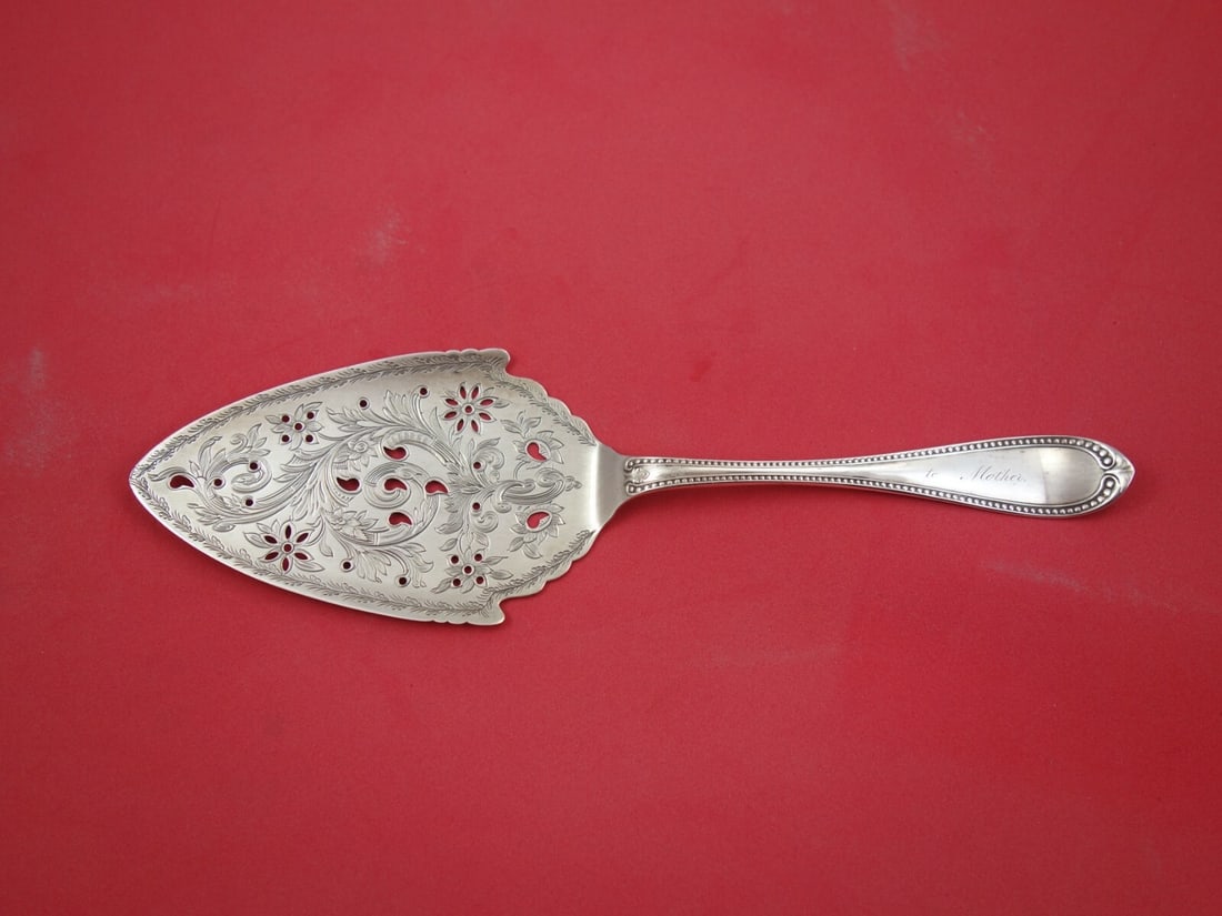 John Polhamus Sterling Silver Cake Server with Pierced Floral Design 9 3/4 in: John Polhamus Sterling Silver Cake Server with Pierced Floral Design 9 3/4 in This exquisite cake server by John Polhamus is crafted from high-quality sterling silver, showcasing a beautiful bright-cu