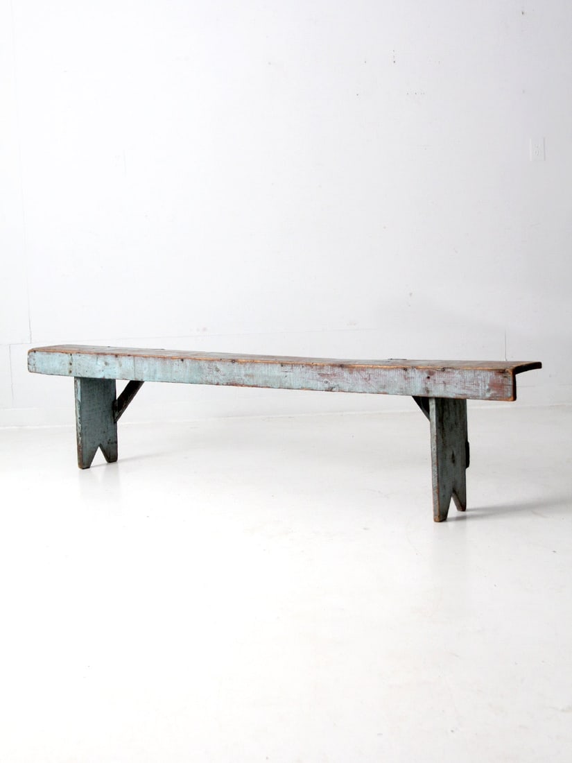 Charming Antique Blue Wooden Bench with Cross Bar Braces: Charming Antique Blue Wooden Bench with Cross Bar Braces This antique wooden bench features a charming eggshell blue color and a slender design, complete with cross bar braces on the back and a lipped