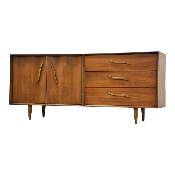 1960s Unagusta Mid Century Walnut Dresser with Sculpted Pulls: 1960s Unagusta Mid Century Walnut Dresser with Sculpted Pulls This stunning mid-century modern dresser from the 1960s is crafted from rich walnut and features elegantly sculpted drawer pulls, adding a