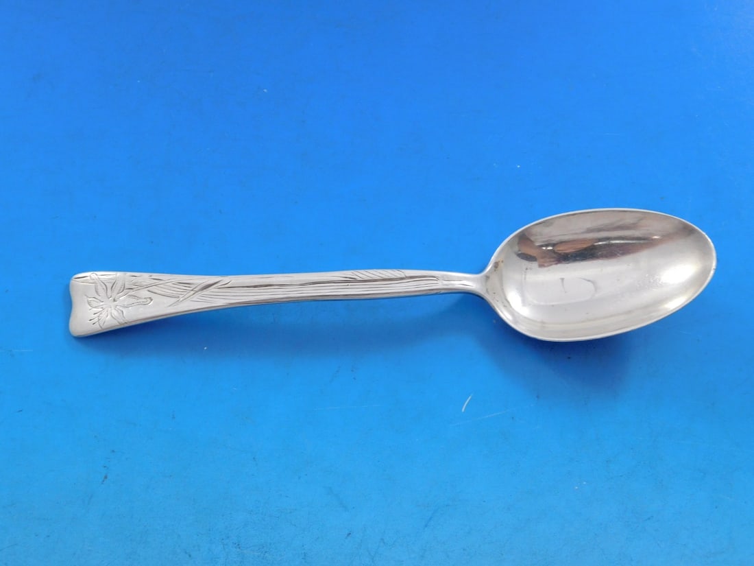 Tiffany & Co. Sterling Silver Teaspoon Lap Over Edge Lily Flower 6": Tiffany & Co. Sterling Silver Teaspoon Lap Over Edge Lily Flower 6" This exquisite teaspoon from Tiffany & Co. features the classic Lap Over Edge pattern, showcasing a delicate lily flower design. Cra