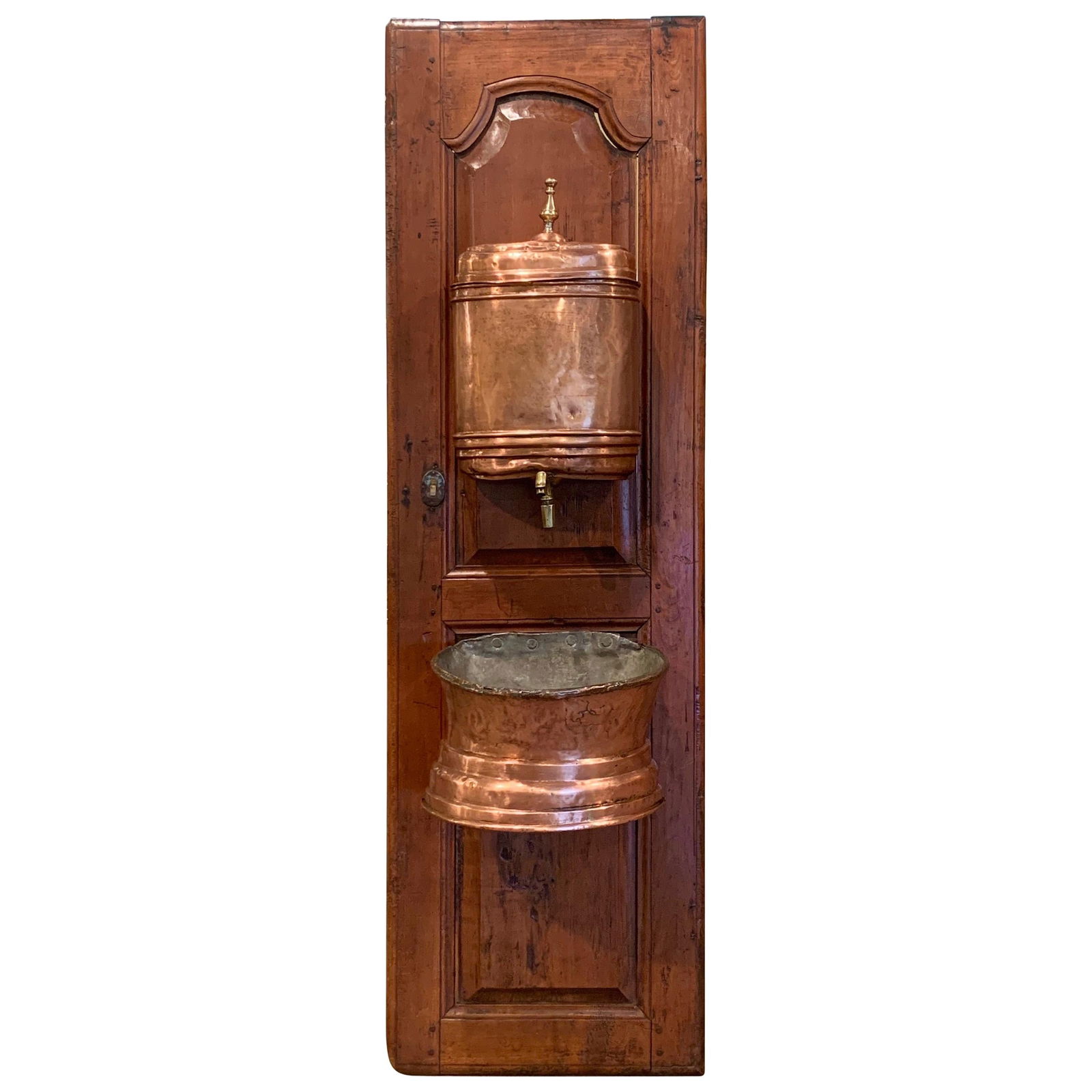 18th Century French Copper Lavabo Fountain on Carved Cherry Door: 18th Century French Copper Lavabo Fountain on Carved Cherry Door Enhance your home with this exquisite late 18th-century French lavabo, originating from Normandy. This remarkable piece features a beau