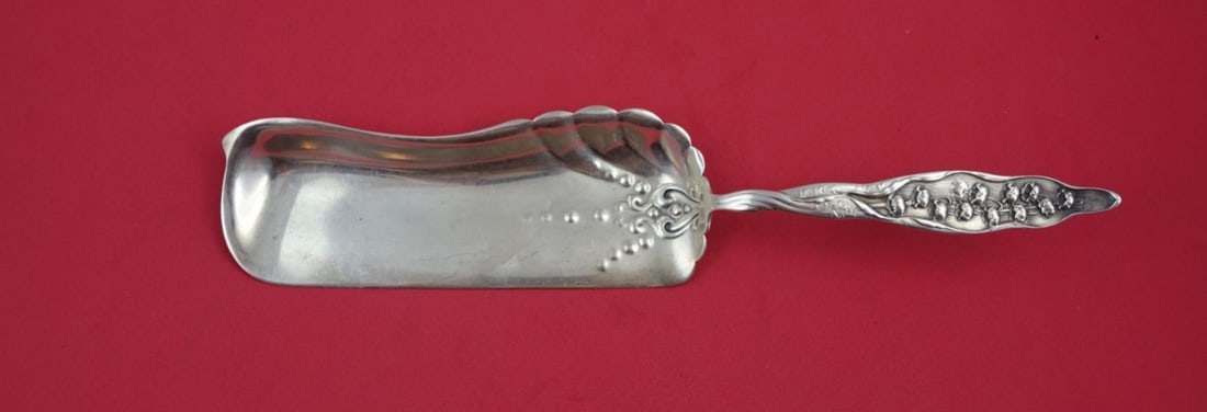 Whiting Sterling Silver 11 Crumber Lily of the Valley Design: Whiting Sterling Silver 11 Crumber Lily of the Valley Design This exquisite crumber, crafted by Whiting, showcases the elegant "Lily of the Valley" pattern, which was patented in 1885. Made of sterlin