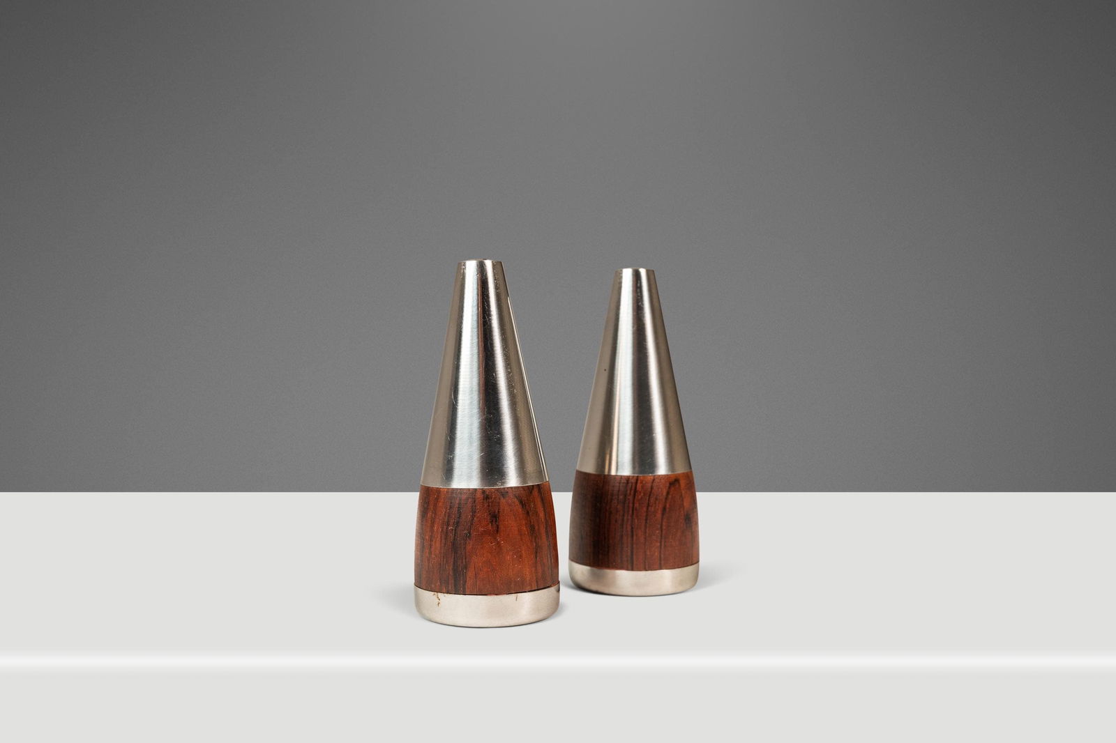 Danish Modern Rosewood Stainless Steel Salt and Pepper Shakers Set of Two 1960s: Danish Modern Rosewood Stainless Steel Salt and Pepper Shakers Set of Two 1960s Enhance your dining experience with this exquisite set of two Mid-Century Danish Modern salt and pepper shakers, crafted