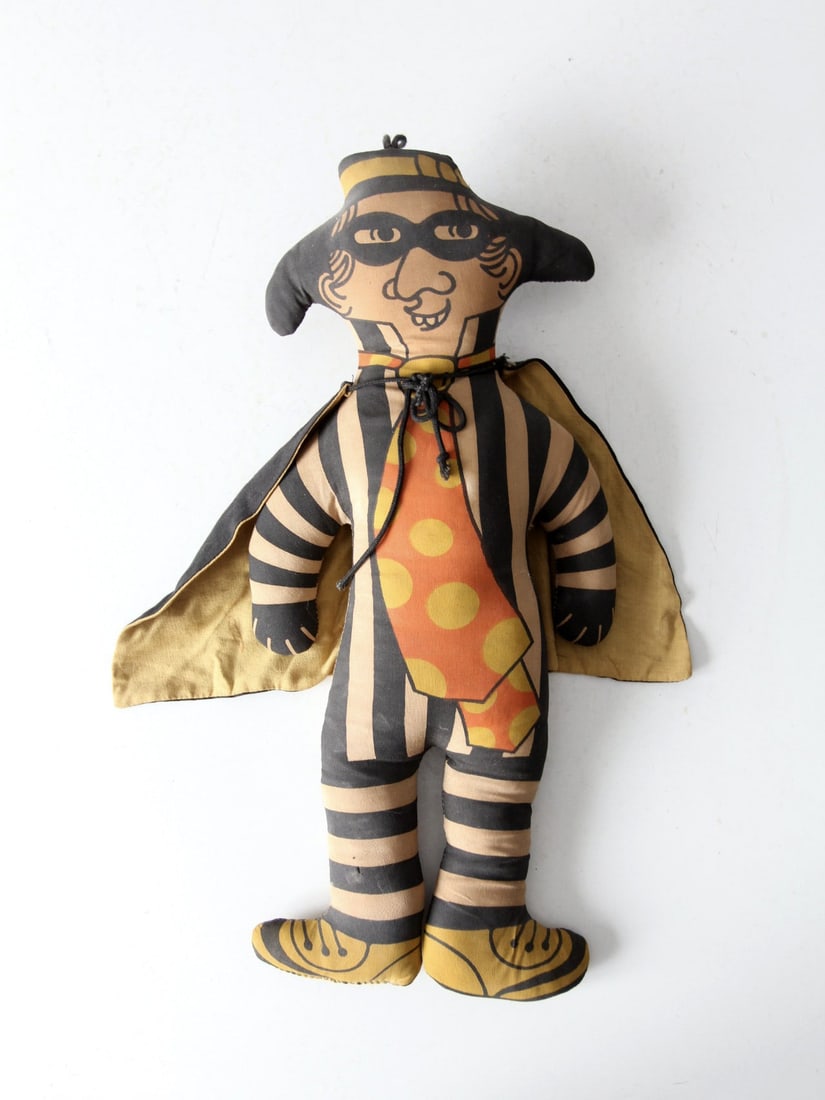 1970s Vintage McDonald's Hamburglar Doll with Removable Cape: 1970s Vintage McDonald's Hamburglar Doll with Removable Cape Robble, Robble! This nostalgic 1970s vintage McDonald's Hamburglar doll is a delightful collector's item. Made from printed cloth, it featu