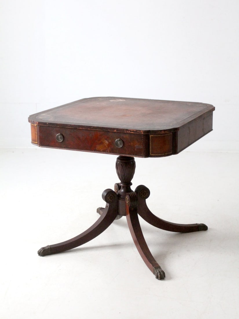 1940s Regency Style Leather Game Table with Drawer: 1940s Regency Style Leather Game Table with Drawer This exquisite Vintage Regency Style Game Table showcases a beautifully leather-covered top and a single pedestal base supported by four elegantly sp