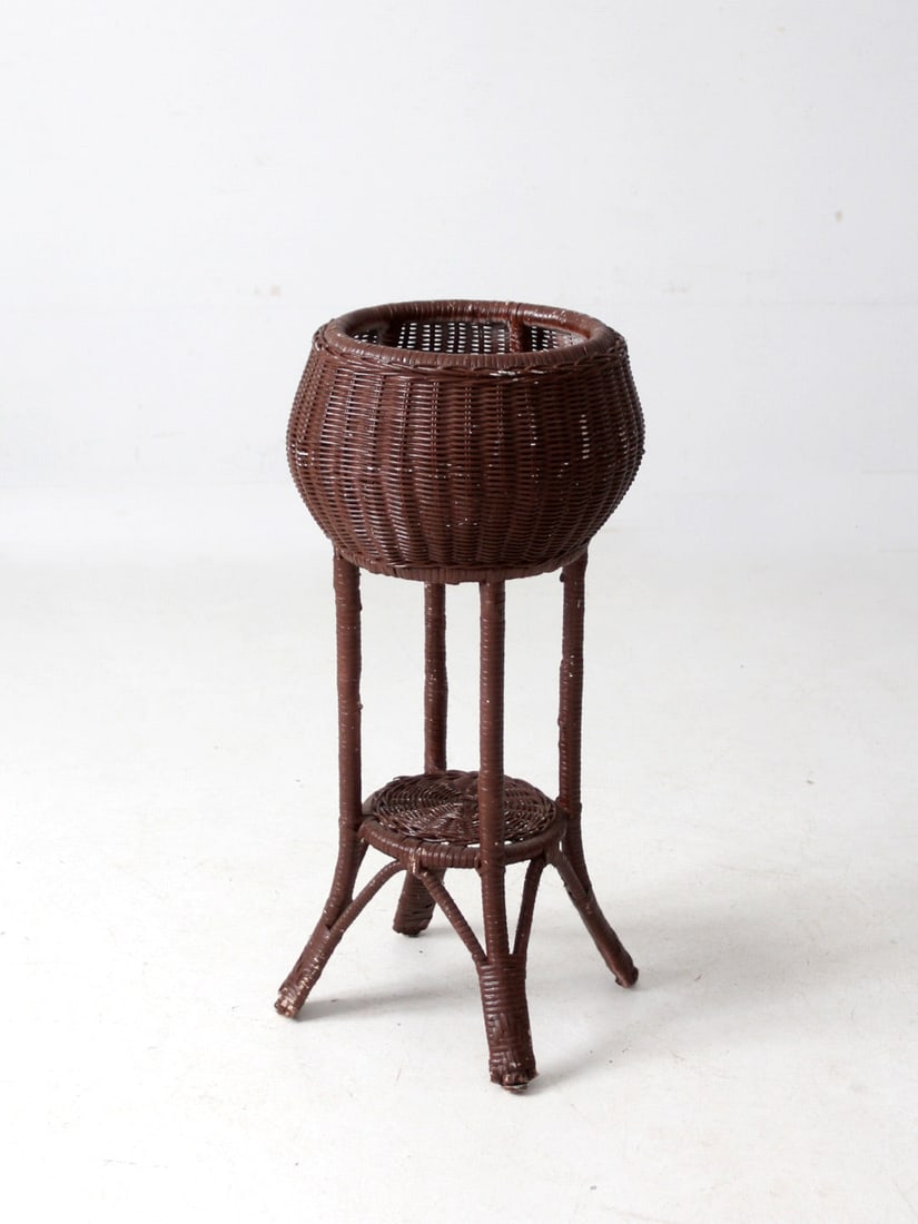 Vintage Wicker Plant Stand with Sculptural Design and Versatile Use: Vintage Wicker Plant Stand with Sculptural Design and Versatile Use This vintage wicker plant stand features a charming rounded basket form supported by tall, tapering legs, complemented by a small wo