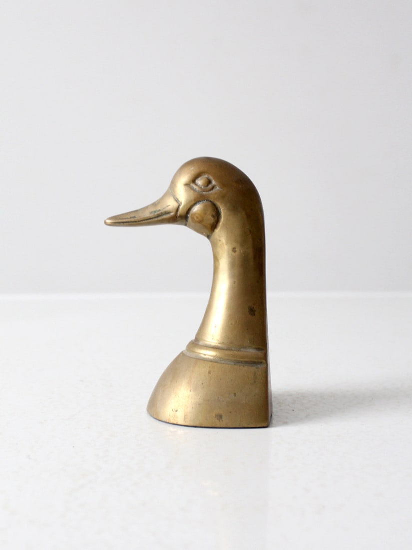 Vintage Mid-Century Brass Duck Bookend Decorative Paperweight: Vintage Mid-Century Brass Duck Bookend Decorative Paperweight This mid-century brass bookend showcases a stylish duck bust design that adds a touch of vintage charm to any setting. With a weighted bas