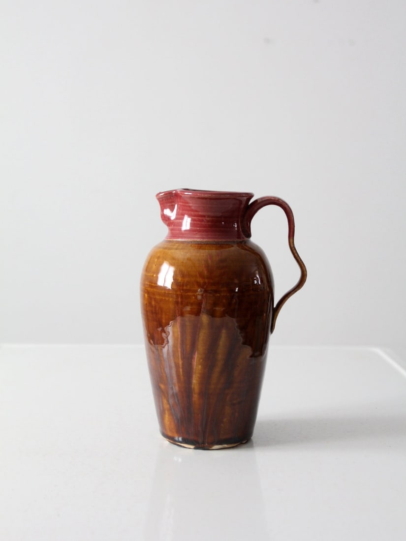 1983 Vintage Studio Pottery Pitcher Handcrafted Brown Maroon Glaze Signed: 1983 Vintage Studio Pottery Pitcher Handcrafted Brown Maroon Glaze Signed This vintage studio pottery pitcher, dated 1983, showcases a unique hand-crafted design with a rich brown and maroon glaze. Th