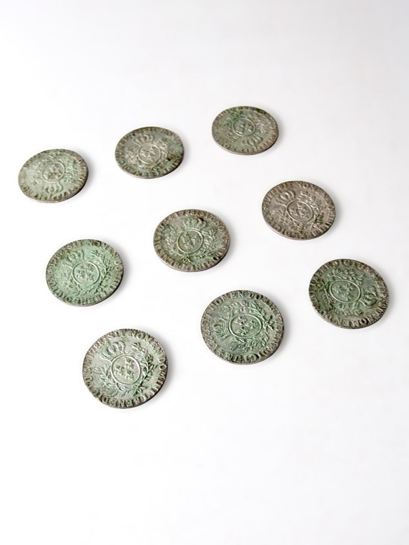 Set of Metal Coasters with French Fleur-de-Lis Medallion Design: Set of Metal Coasters with French Fleur-de-Lis Medallion Design This vintage mid-century set includes metal coasters adorned with classic French heraldic and neoclassical motifs, featuring a fleur-de-