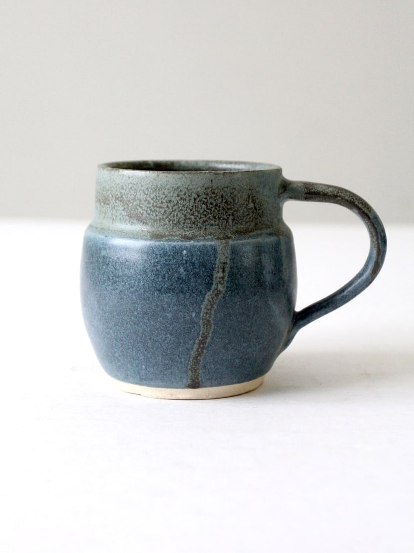 Handmade Vintage Studio Pottery Mug with Blue Sage Glaze: Handmade Vintage Studio Pottery Mug with Blue Sage Glaze This vintage studio pottery mug showcases a unique handmade design, featuring a rich blue and speckled sage dripped glaze. The mug is signed by