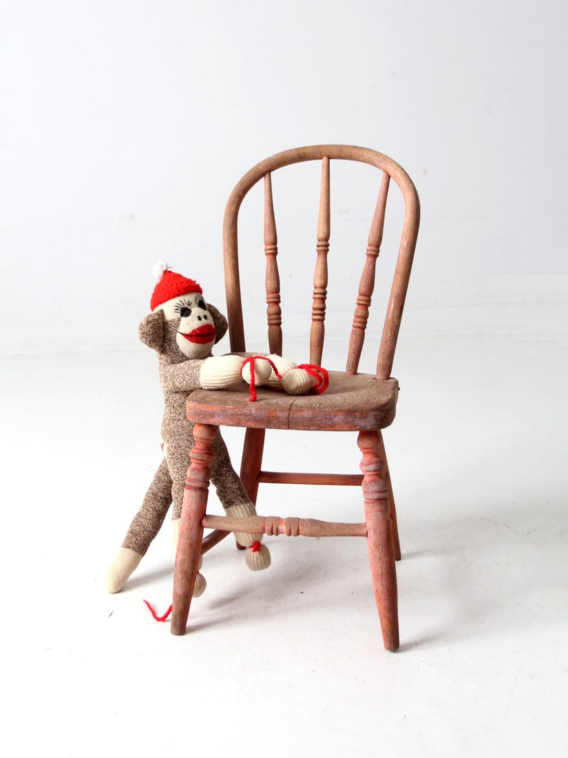 Antique Children's Spindle Back Chair in Faded Red Finish: Antique Children's Spindle Back Chair in Faded Red Finish This charming antique children's spindle back chair showcases a classic design with elegantly turned legs and a faded red finish that enhances
