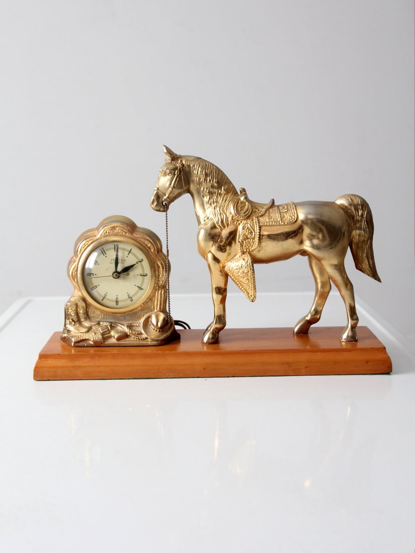 Vintage Mid Century United Self-Starting Horse Clock with Cowboy Theme: Vintage Mid Century United Self-Starting Horse Clock with Cowboy Theme This mid 20th century vintage United self-starting mantle clock showcases a charming American west theme. It features a brass hor