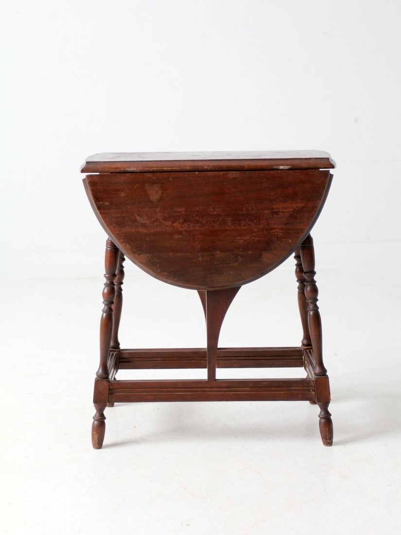 Mid-20th Century Colonial Style Drop Leaf Side Table: Mid-20th Century Colonial Style Drop Leaf Side Table This mid-20th century vintage Colonial style drop leaf side table showcases classic turned legs and a rich, timeworn finish. Its adaptable design m