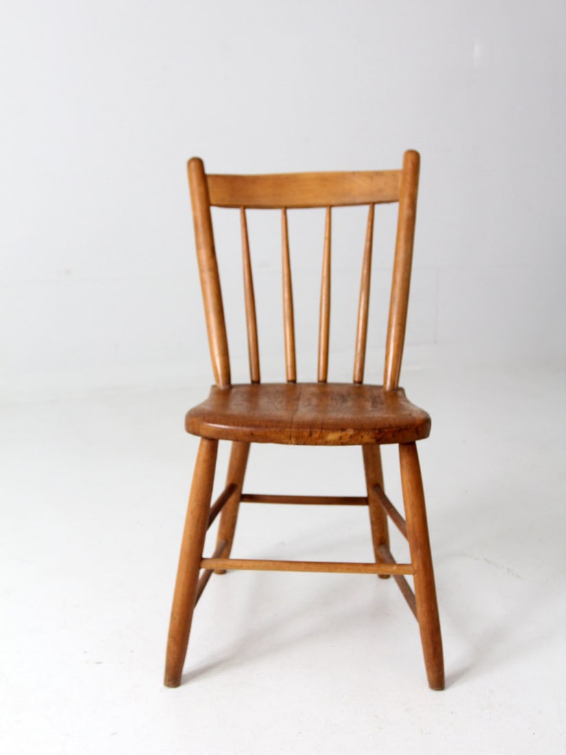 Rustic Antique Farmhouse Chair with Plank Seat and Spindle Back: Rustic Antique Farmhouse Chair with Plank Seat and Spindle Back This antique farmhouse chair embodies a rustic charm with its primitive design, featuring a sturdy plank seat and a classic spindle back