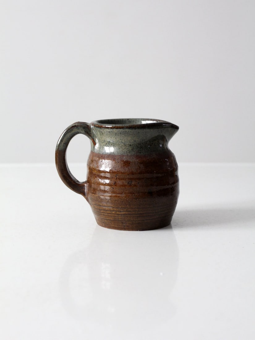 Signed Vintage Studio Pottery Creamer with Brown Glaze: Signed Vintage Studio Pottery Creamer with Brown Glaze This vintage studio pottery creamer showcases exquisite craftsmanship with a rich brown glaze complemented by an olive green neck and interior. S