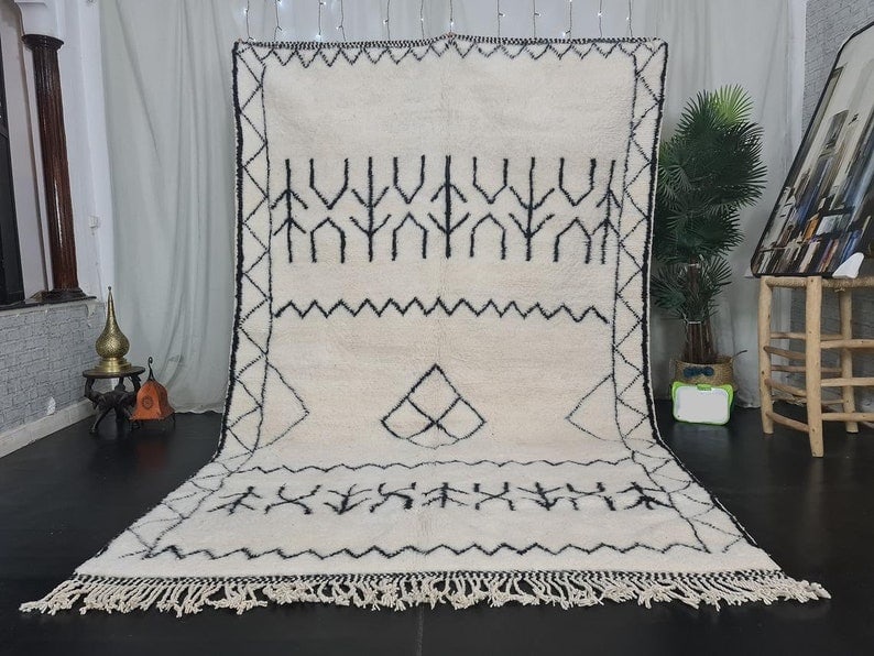 Authentic Handmade White Rug with Black Patterns from Morocco: Authentic Handmade White Rug with Black Patterns from Morocco Experience the warmth and charm of this Authentic Soft White Handmade Rug. Featuring intricate black patterns and symbols, this stunning p