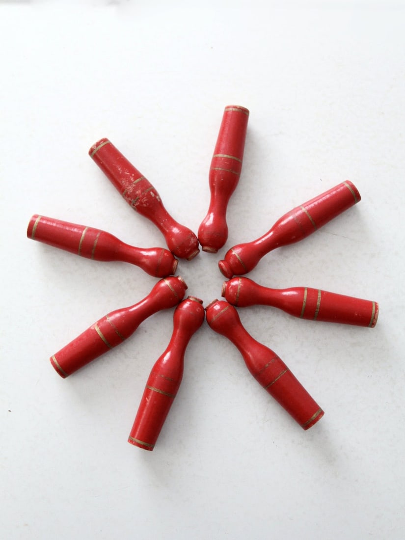 Antique Red Wooden Skittles Set of 8 with Gold Striping: Antique Red Wooden Skittles Set of 8 with Gold Striping This charming set of eight antique wooden skittles dates back to the early 20th century. Each skittle is beautifully crafted from red wood and f