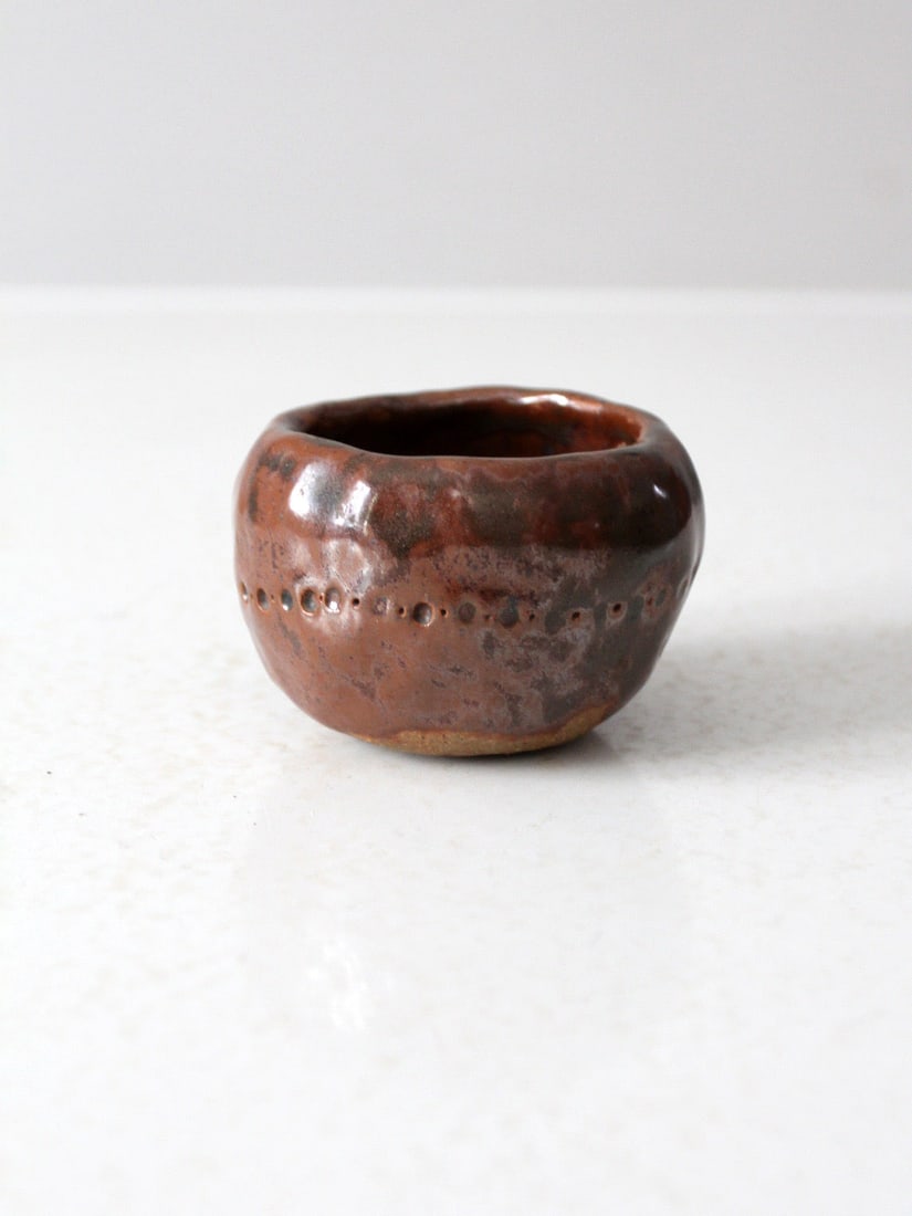 Vintage Earthy Brown Studio Pottery Bowl with Impressed Dots: Vintage Earthy Brown Studio Pottery Bowl with Impressed Dots This vintage studio pottery bowl showcases an earthy brown glaze that beautifully displays subtle red undertones and a soft metallic sheen,