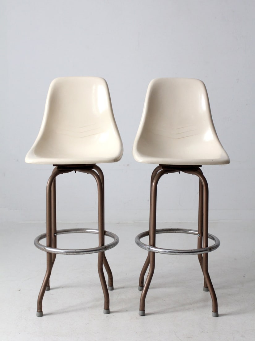Vintage Mid Century Fiberglass Shell Swivel Stools Pair: Vintage Mid Century Fiberglass Shell Swivel Stools Pair Elevate your kitchen or bar area with this pair of Mid Century Fiberglass Shell Swivel Bar Stools, showcasing a timeless mid-century modern desi