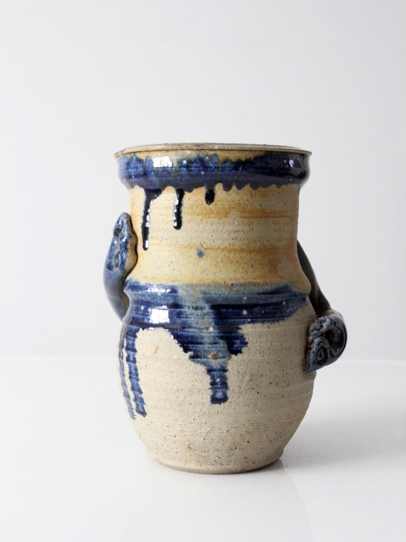 Bold Vintage Studio Pottery Vase with Blue Drip Detail: Bold Vintage Studio Pottery Vase with Blue Drip Detail Introducing a striking vintage studio pottery vase, showcasing a unique handmade design. This vase features a bold abstract style with a rich tan