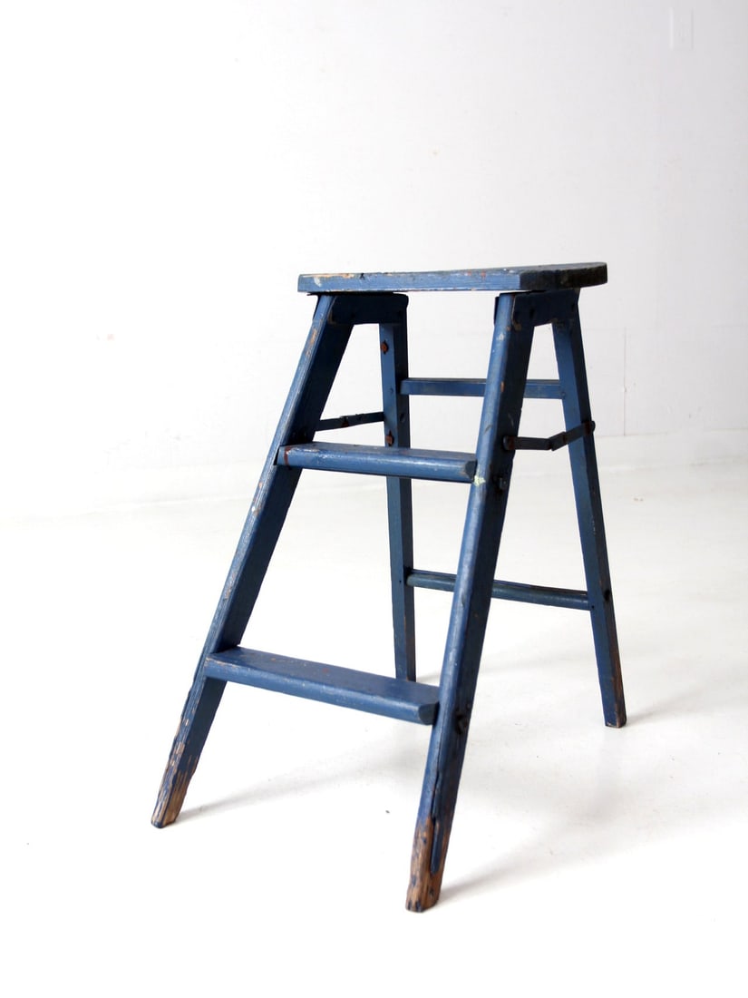 Vintage Cerulean Blue Wooden Step Stool with Metal Hinges: Vintage Cerulean Blue Wooden Step Stool with Metal Hinges This vintage wooden step stool features a charming cerulean blue finish, enhancing its rustic appeal. Designed for practicality, the stool inc