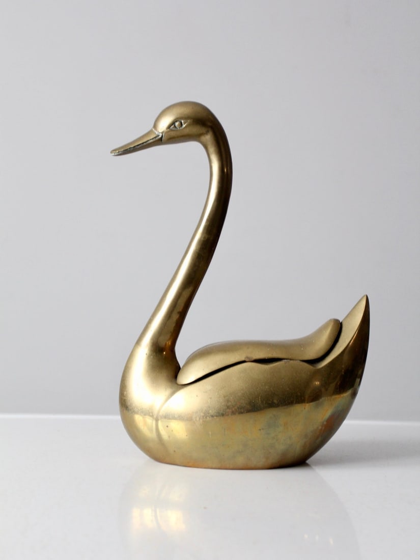 Vintage Mid-Century Brass Swan Figurine Box with Hidden Storage: Vintage Mid-Century Brass Swan Figurine Box with Hidden Storage This exquisite mid-century brass swan figurine is a perfect blend of art and functionality. It features a detailed design with a lid tha