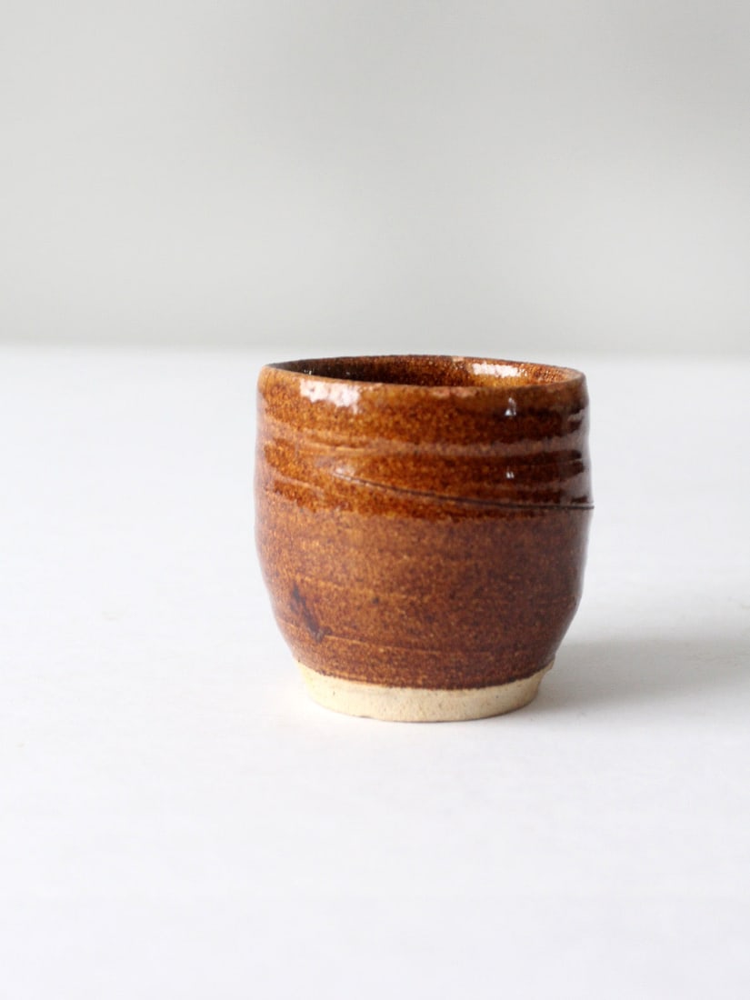 Handmade Vintage Studio Pottery Cup Vase with Russet Brown Glaze: Handmade Vintage Studio Pottery Cup Vase with Russet Brown Glaze This vintage studio pottery cup vase is a charming addition to any collection. Handmade on a wheel, it showcases a warm russet brown gl