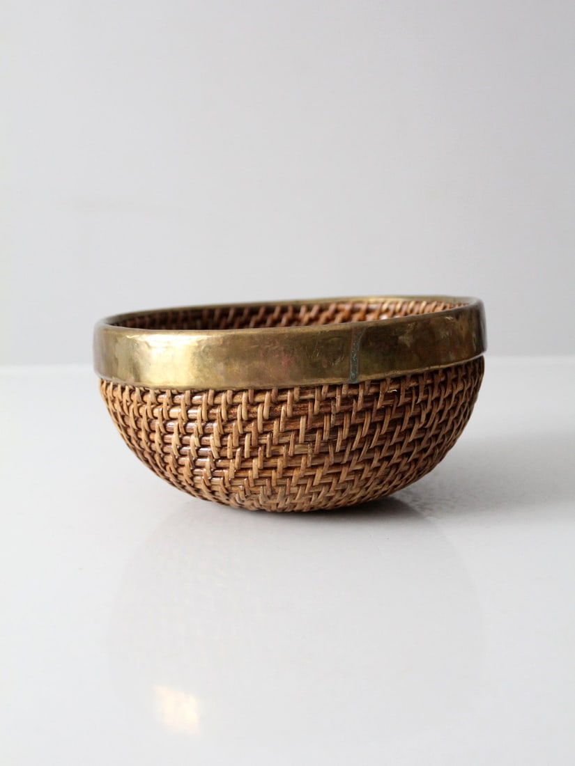 Woven Rattan Decorative Bowl Featuring Brass Rim Mid-Century Design: Woven Rattan Decorative Bowl Featuring Brass Rim Mid-Century Design This mid-century bowl features a tightly woven rattan construction with a rounded form and is finished with a warm brass rim. The co