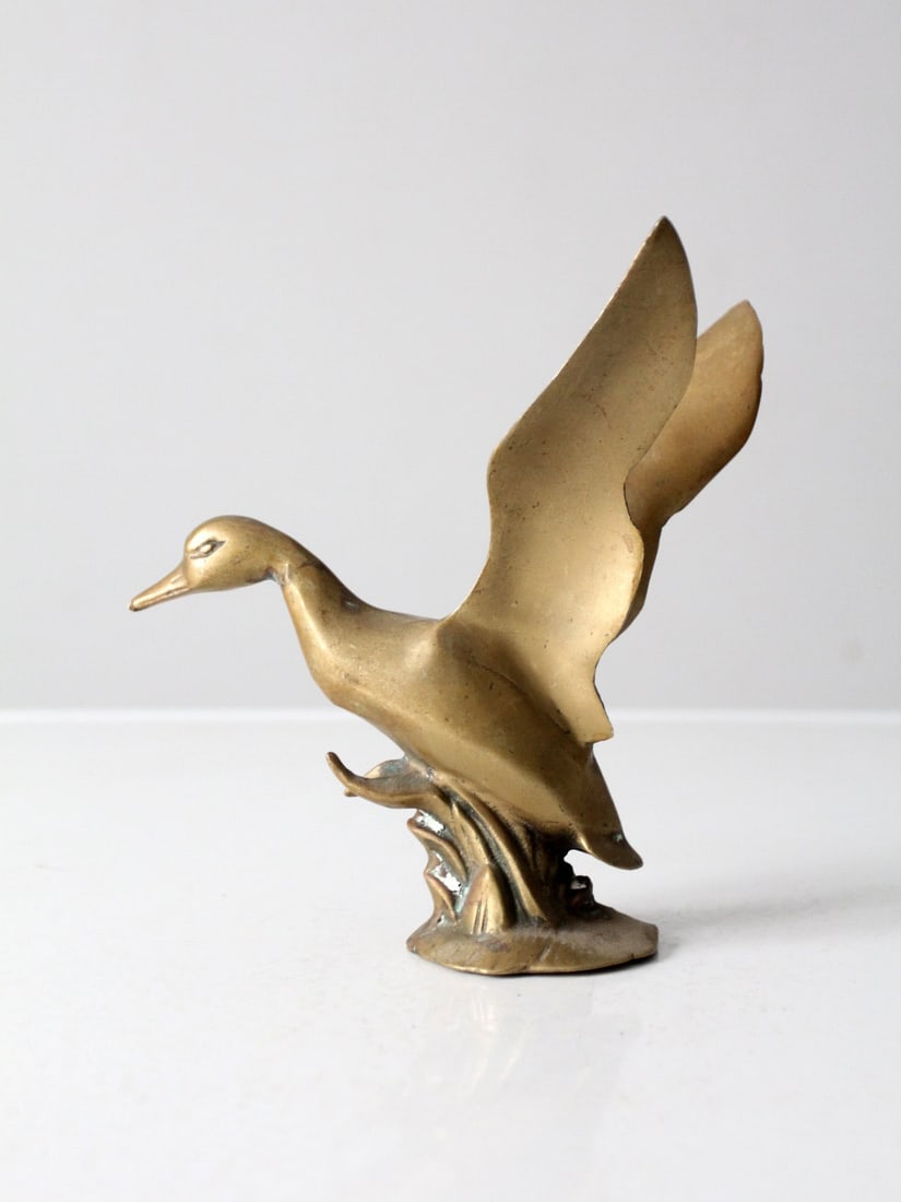Mid-Century Brass Duck Figurine 7.5 x 5 x 8.25 Inches: Mid-Century Brass Duck Figurine 7.5 x 5 x 8.25 Inches This mid-century brass duck figurine beautifully captures the motion and grace of a bird rising from water. The elegantly sculpted wings sweep upw