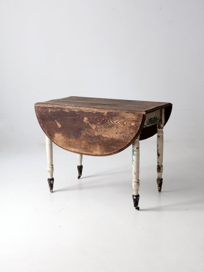 Vintage Antique Drop Leaf Dining Table with Casters: Vintage Antique Drop Leaf Dining Table with Casters This antique drop leaf table beautifully blends vintage charm with practical functionality, making it an ideal choice for smaller spaces. The wooden