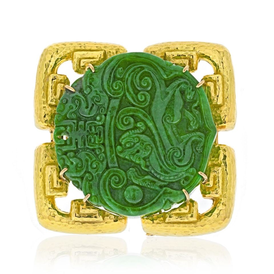 David Webb 18K Yellow Gold Jade Brooch Ancient World Design: David Webb 18K Yellow Gold Jade Brooch Ancient World Design This exquisite brooch by David Webb features a stunning carved round jade centerpiece, known for its rich apple green hue. Crafted from a co