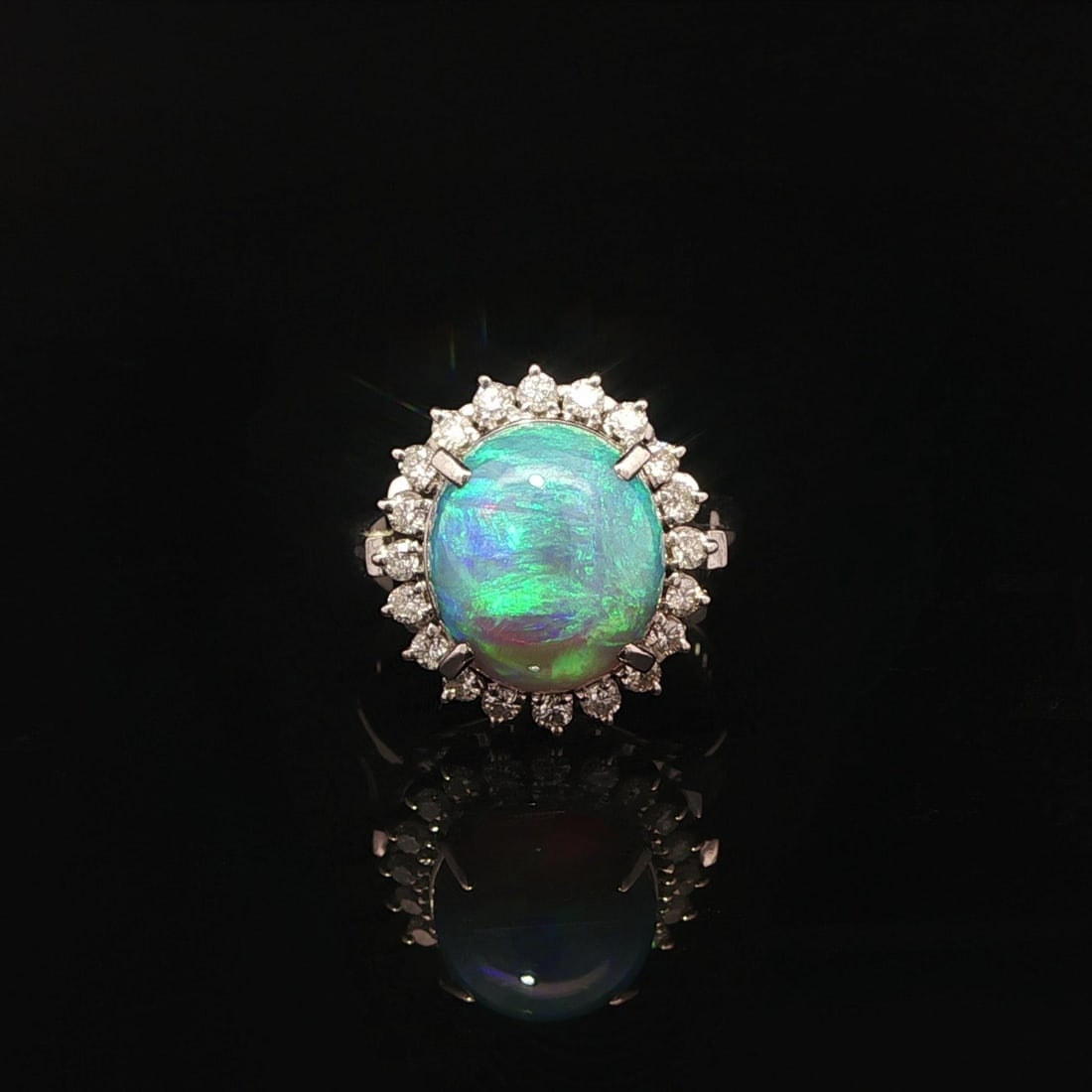 Platinum Cocktail Ring with GIA Certified Fiery Gray Opal and Diamond Halo: Platinum Cocktail Ring with GIA Certified Fiery Gray Opal and Diamond Halo This cocktail ring features a natural gray opal with a vivid play of color, certified by GIA, set in solid platinum. The opal