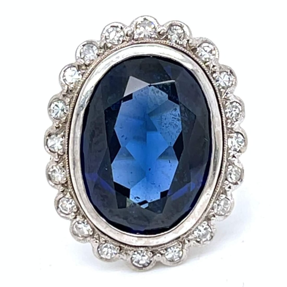 Art Deco 18K White Gold Ring with 10.00 Ct Synthetic Sapphire and 20 Diamonds: Art Deco 18K White Gold Ring with 10.00 Ct Synthetic Sapphire and 20 Diamonds This exquisite Art Deco ring features a stunning 18K white gold setting, adorned with a vibrant synthetic sapphire weighin