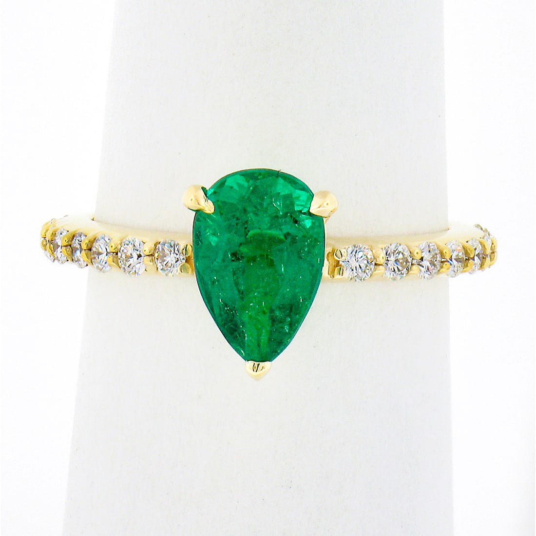 SSEF Certified 18K Yellow Gold Pear Emerald & Diamond Engagement Ring: SSEF Certified 18K Yellow Gold Pear Emerald & Diamond Engagement Ring This exquisite engagement ring features a stunning natural pear cut emerald at its center, weighing 1.42 ct and displaying a vivid