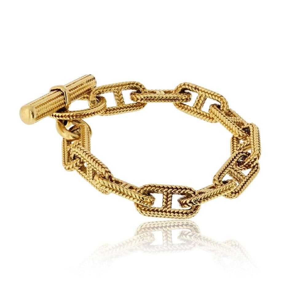 18K Yellow Gold Bracelet from Hermes Toggle Collection: 18K Yellow Gold Bracelet from Hermes Toggle Collection This bracelet is crafted from 18K yellow gold and features a toggle clasp design. It is a pre-owned piece from Hermes, known for its luxurious cr