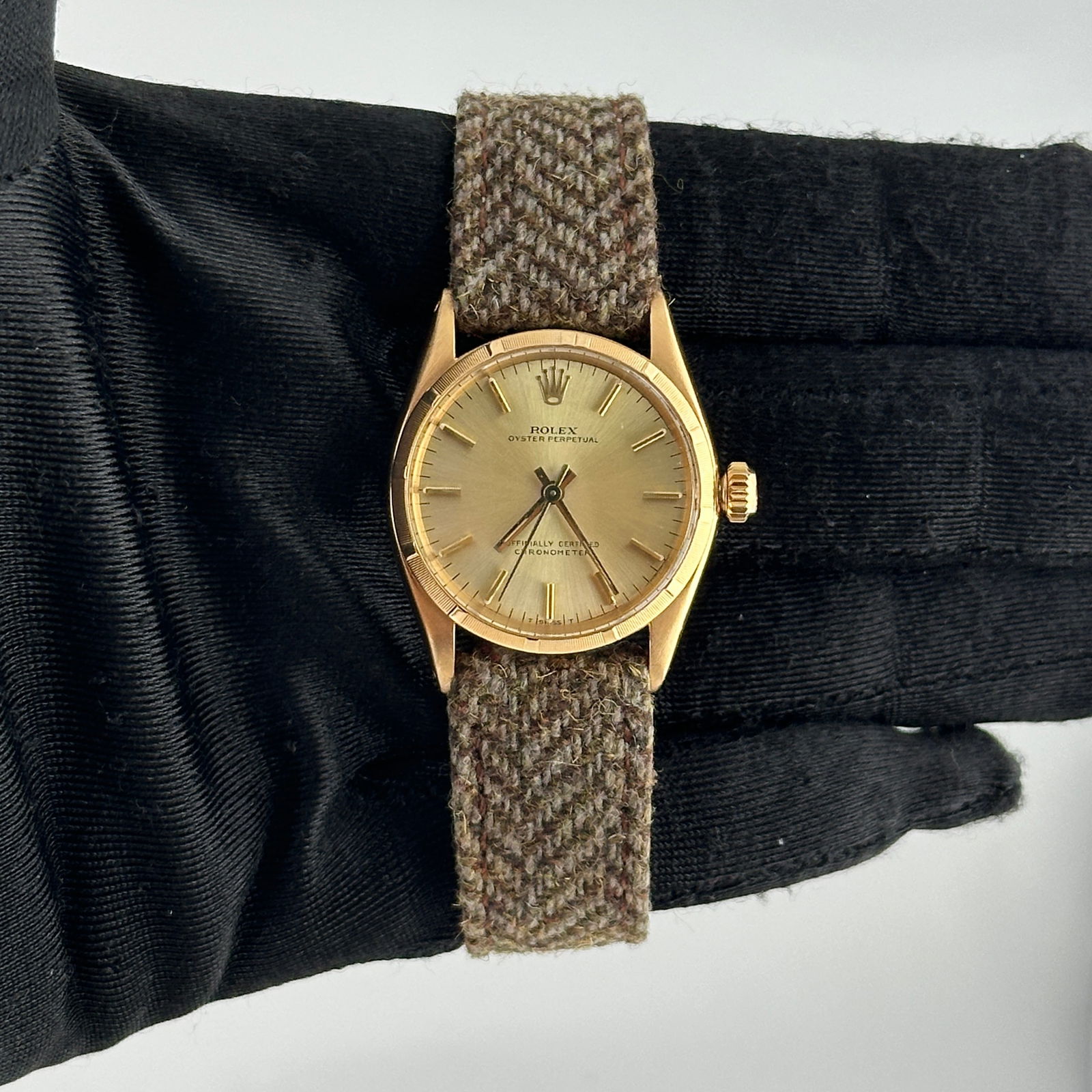 Ladies Oyster Perpetual Watch Champagne Stick Dial Fabric Band Ref 6549: Ladies Oyster Perpetual Watch Champagne Stick Dial Fabric Band Ref 6549 This Rolex Oyster Perpetual watch features a champagne stick dial and an engine turned bezel. Designed for ladies, it is paired
