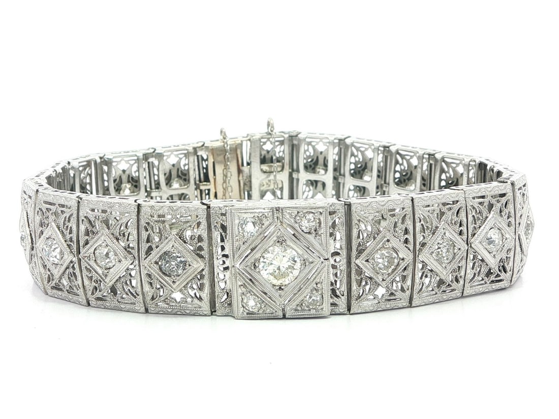 Art Deco Era Filigree Bracelet in White Gold with Platinum and Old Mine Diamonds: Art Deco Era Filigree Bracelet in White Gold with Platinum and Old Mine Diamonds This antique Art Deco bracelet features intricate filigree and milgrain work crafted from solid 13-14k white gold with