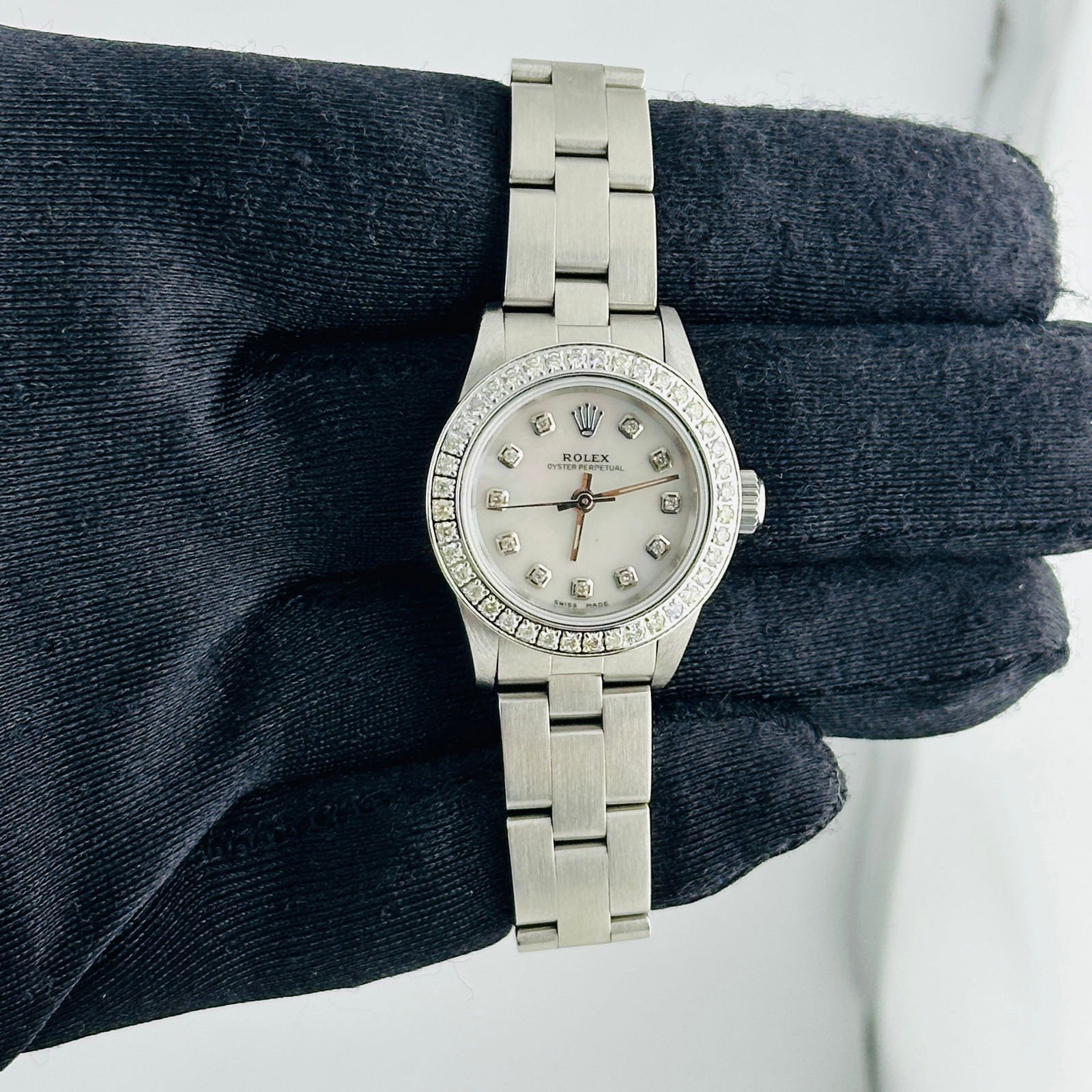 Diamond Bezel Rolex Oyster Ref 67180 White MOP Dial with Papers 1997: Diamond Bezel Rolex Oyster Ref 67180 White MOP Dial with Papers 1997 This Rolex Oyster Perpetual features a men's Aftermarket White Mother of Pearl diamond dial and a diamond bezel. The watch is fitte