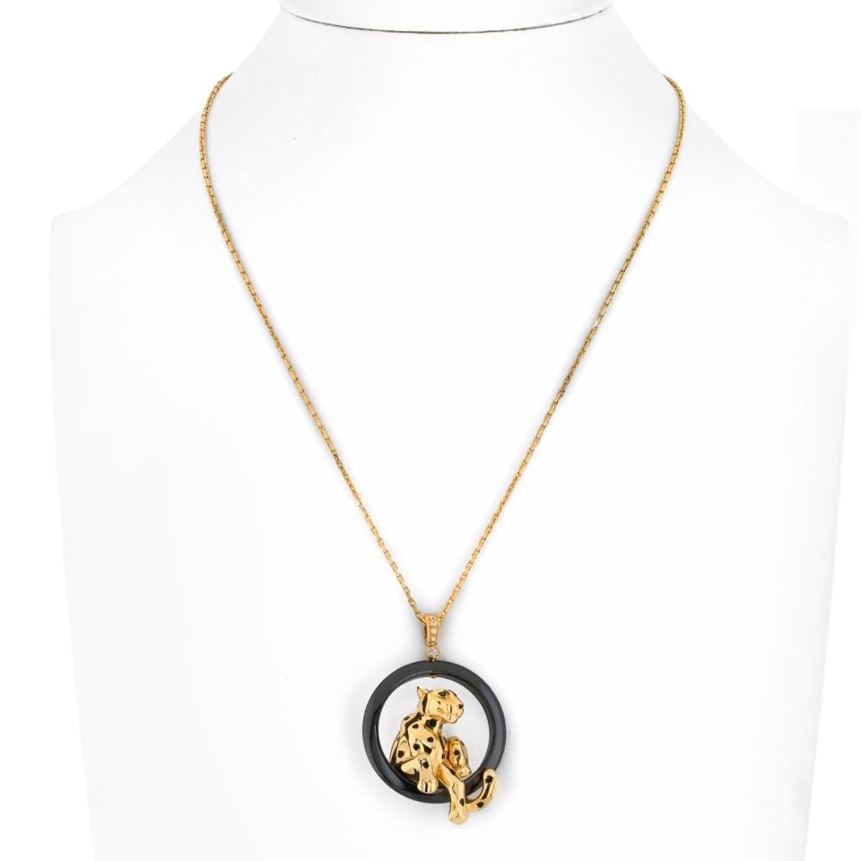 Cartier 18K Yellow Gold Panther Necklace with Black Onyx and Tsavorite Garnets: Cartier 18K Yellow Gold Panther Necklace with Black Onyx and Tsavorite Garnets This exquisite necklace features an 18K yellow gold panther pendant, elegantly perched on a striking black onyx ring. The