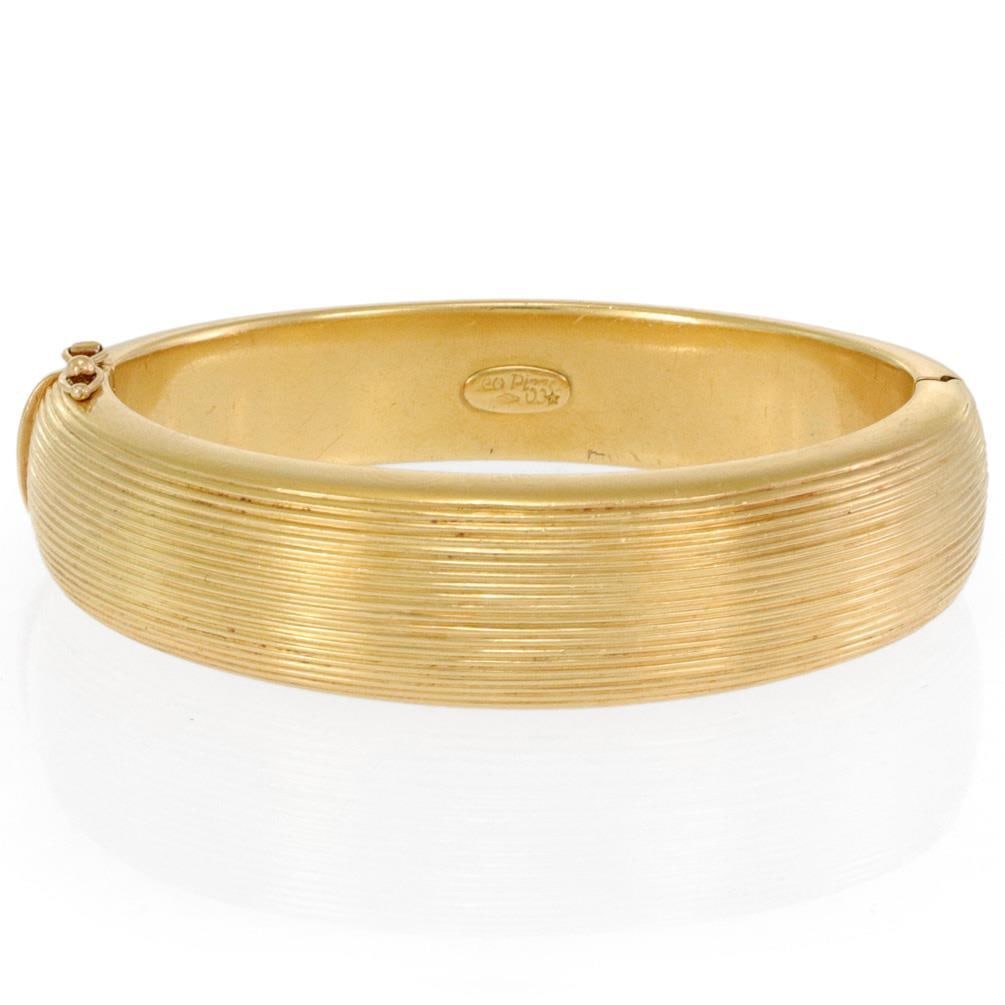 Leo Pizzo 18k Yellow Gold 16mm Oval Dome Bangle with Hallmark: Leo Pizzo 18k Yellow Gold 16mm Oval Dome Bangle with Hallmark This exquisite bangle by designer Leo Pizzo showcases a chic and authentic design. Crafted from 18k yellow gold, it features a fine groove