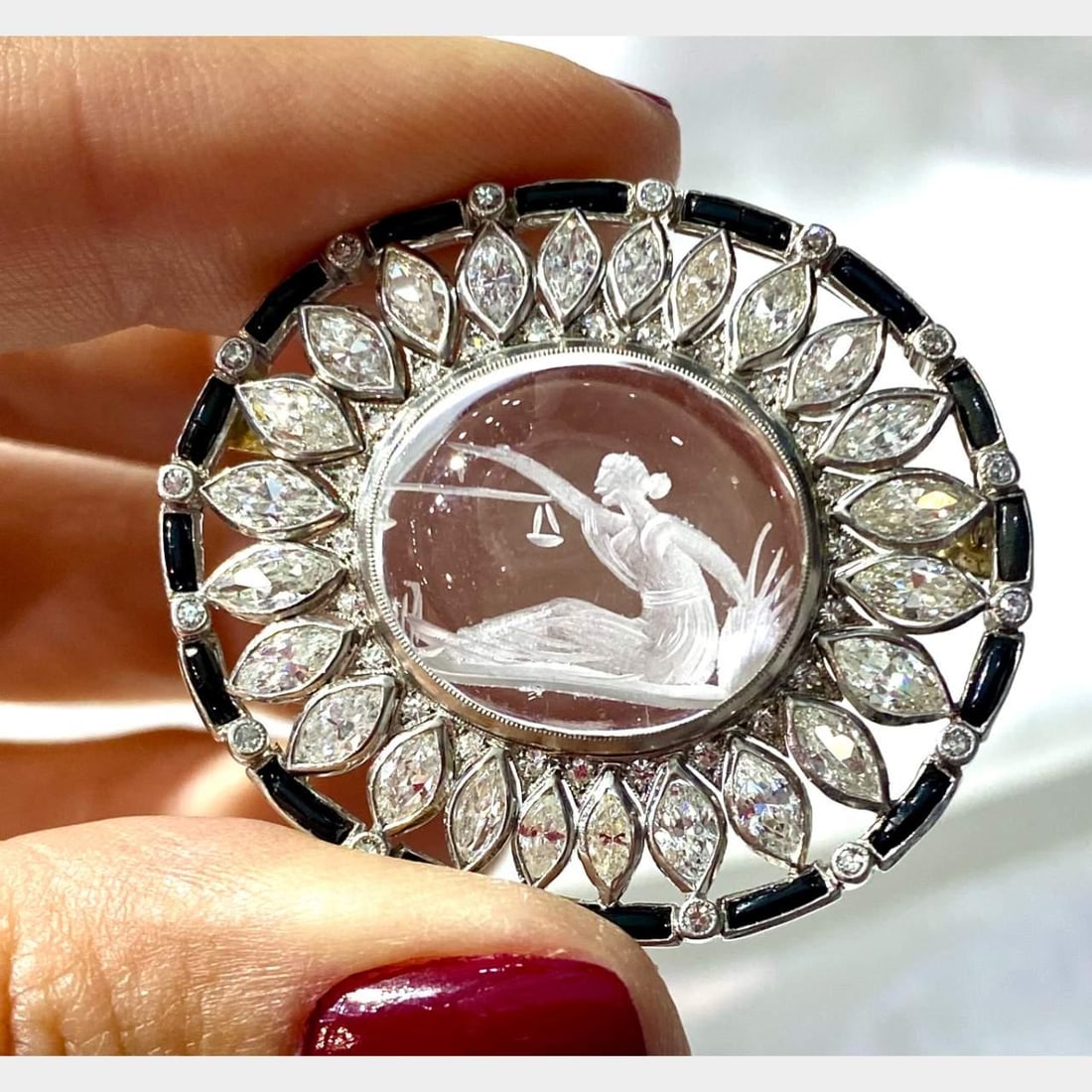 Art Deco Lady Justice Platinum Brooch with Diamonds and Rock Crystal: Art Deco Lady Justice Platinum Brooch with Diamonds and Rock Crystal This exquisite Art Deco Lady Justice brooch is crafted in platinum and features a stunning design. It is adorned with 24 marquise d