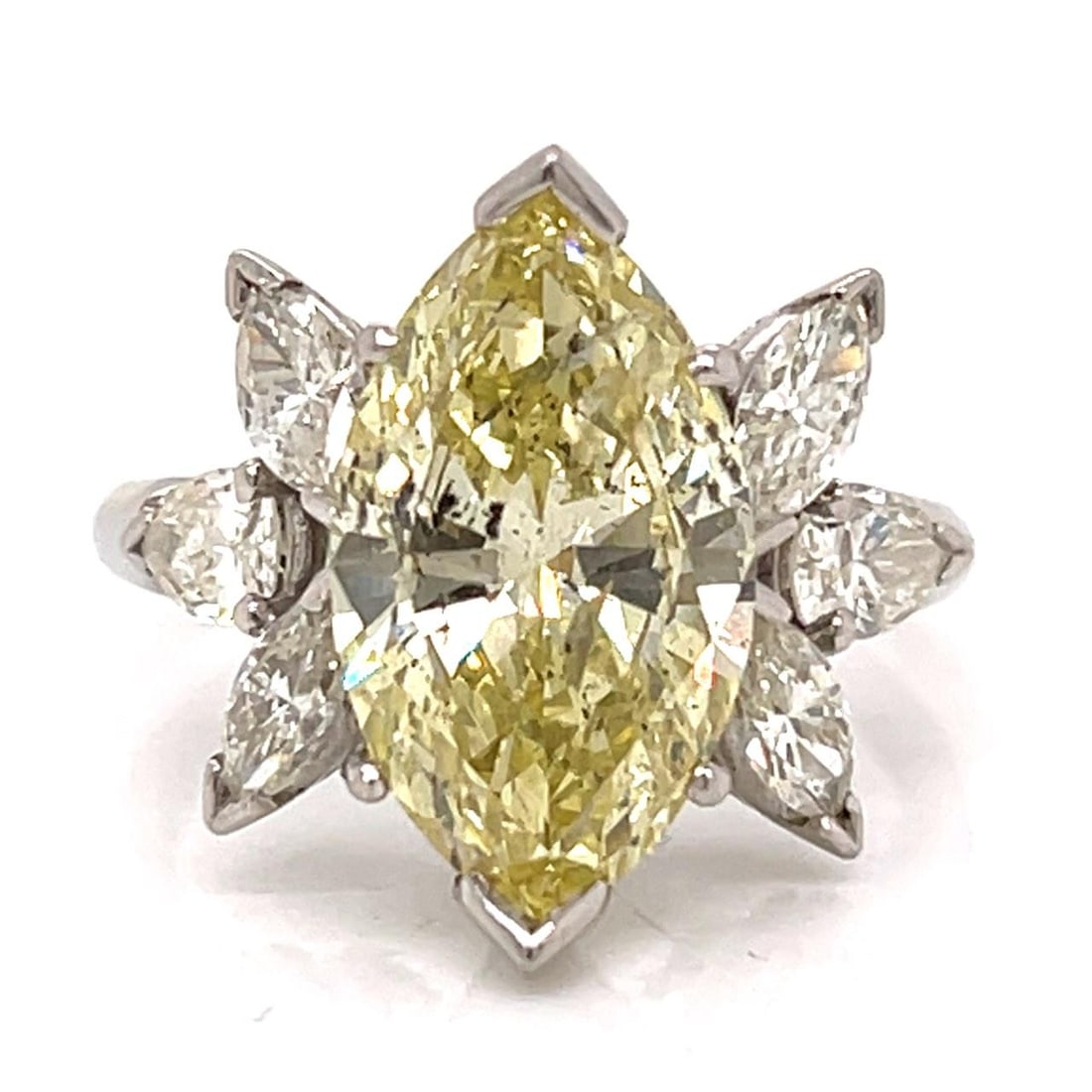 Platinum Marquise Fancy Yellow Diamond Ring With Six Accent Diamonds Circa 1950s: Platinum Marquise Fancy Yellow Diamond Ring With Six Accent Diamonds Circa 1950s This 1950s platinum ring features a fancy yellow marquise diamond, approximately 6.00 carats with I1 clarity. The cente