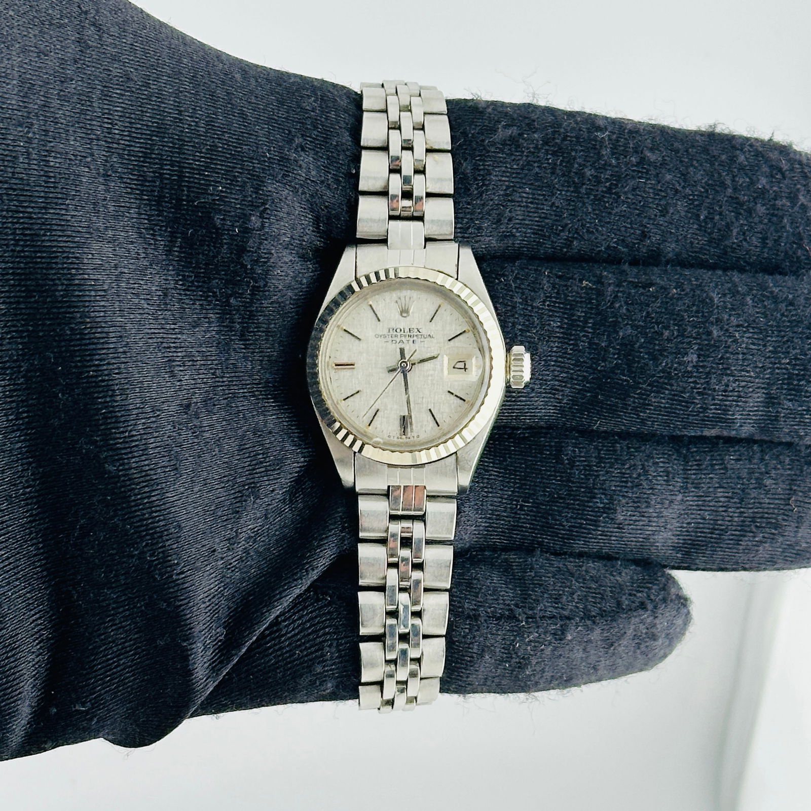Ladies Rolex Oyster Perpetual Date 6917/4 Silver Linen Dial Folded Jubilee: Ladies Rolex Oyster Perpetual Date 6917/4 Silver Linen Dial Folded Jubilee This ladies Rolex Oyster Perpetual Date features a silver linen dial and a fluted bezel. The watch is fitted with a folded Ju