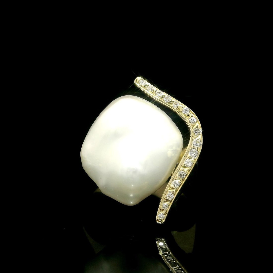 18k Yellow Gold Cocktail Ring with Pearl and Diamond Accents: 18k Yellow Gold Cocktail Ring with Pearl and Diamond Accents This exquisite 18k Yellow Gold ring features a stunning cultivated button pearl at its center, complemented by diamond accents. The pearl s